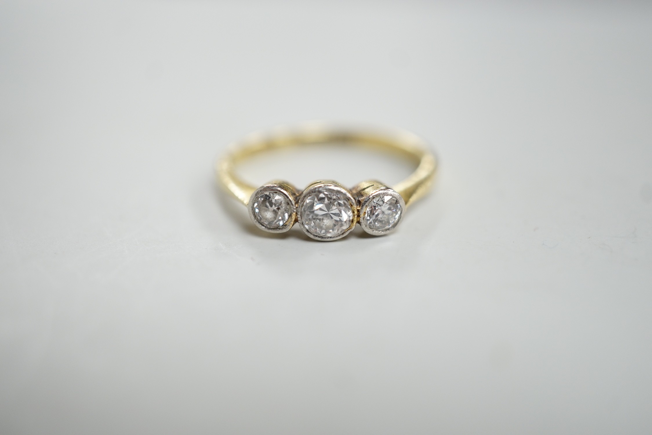 A mid 20th century 18ct, plat and three stone collet set diamond ring, size M, gross weight 2.5 grams.